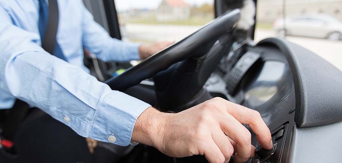 Busfahrer am Lenkrad eines Busses während der Fahrt