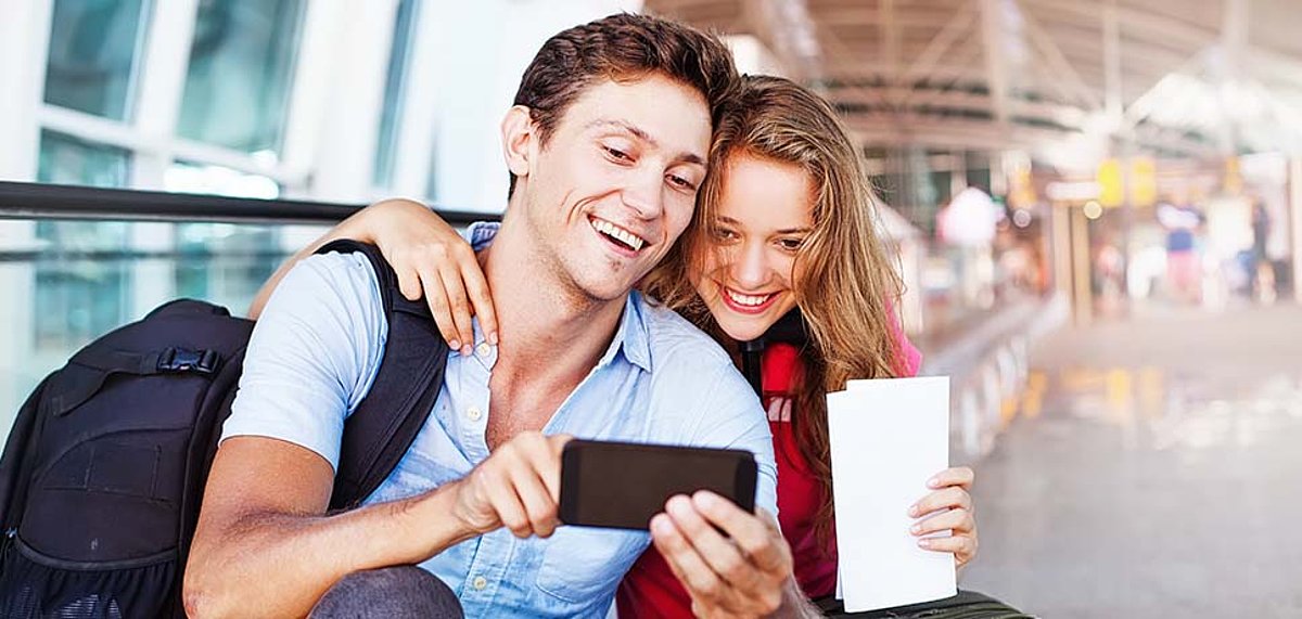 Zwei junge Reisende schauen sich etwas auf dem Handy an
