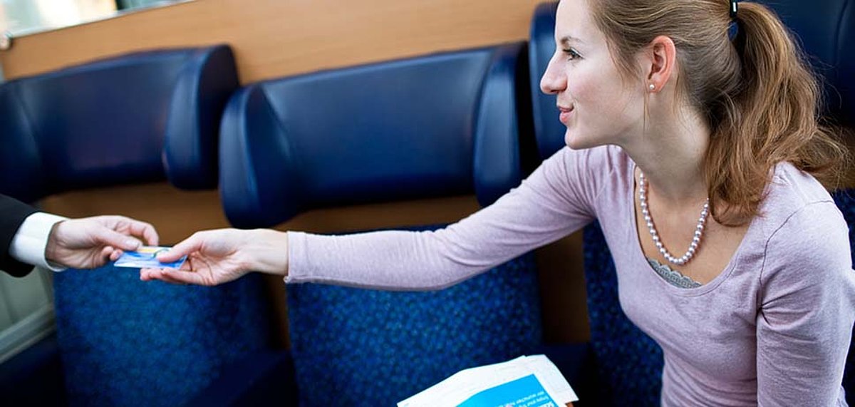 Frau zeigt Fahrkarte in der Bahn vor